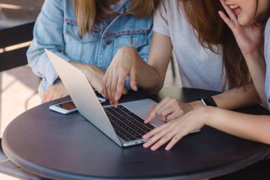 Grup kadınların güzel akıllı iş serbest Asya smart casual giyim yaratıcı ofis veya kafeterya masada otururken dizüstü bilgisayar ya da bilgisayar üzerinde birlikte çalışma.
