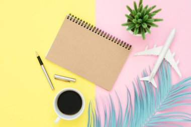 Seyahat etmek yaz kavramı - üstten görünüm mockup boş kağıt defter, kalem, pastel yaprak, kahve ve pembe sarı pastel renkli ekran uçakta, düz yatıyordu tasarımı. Yaz aylarında pastel renk arka plan üzerinde seyahat.