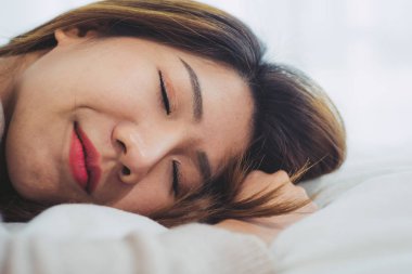 Sabahleyin yatakta uyuyan güzel genç Asyalı kadın. Çekici Asyalı kız rahat yatak odasında uyku zamanı kullanın. Gevşeme yatak odası. Hayat tarzı Asya kadın ev concept.