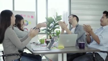 Grup, neşeli Asya yaratıcı iş kadın ve erkek zevk ve having fun iş yerinde çalışırken dans. Grup ofis fikirleri tartışmak raslantı giyimli iş adamları.