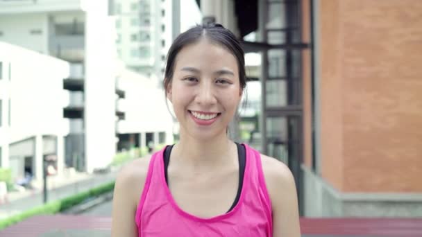 健康美丽的年轻亚洲跑步者妇女在城市街头跑步后 感觉很开心 面带微笑 看着镜头 生活方式适合和活跃的妇女锻炼在城市概念 — 图库视频影像