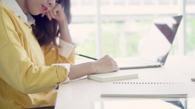 Asyalı kadın çalışma dizüstü evde oturma odasında masa üzerinde gülümseyen güzel genç. Asya iş kadını defter belge finans ve hesap makinesi ev ofis yazma. Ev concept anda zevk.