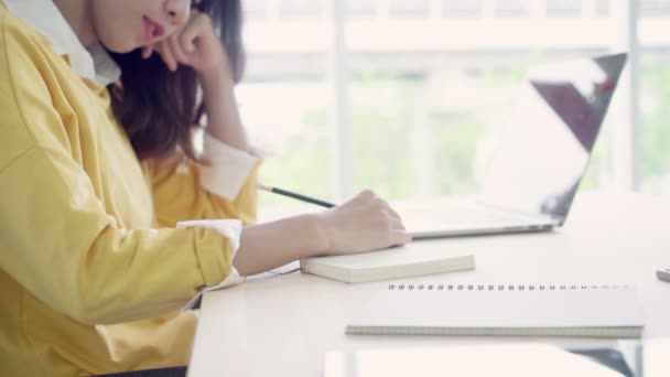 美丽的年轻微笑的亚洲妇女工作笔记本电脑在客厅在家里 亚洲女商人在本家办公室写笔记本文件财务和计算器 享受在家的时间概念 — 图库视频影像
