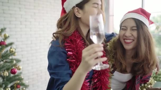 快乐的亚洲妇女在她的办公室里和朋友们一起庆祝圣诞晚会 女性一起庆祝新年和圣诞节 女孩戴圣诞老人帽子喝酒在办公室 — 图库视频影像