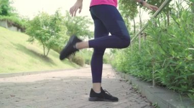 Sağlıklı güzel genç Asyalı sporcu kadın ısınma ve germe kentsel şehir park Caddesi üzerinde çalıştırmak için hazır için kollarını bacaklarını giyim spor. Yaşam tarzı aktif kadınlara şehir kavramında egzersiz.