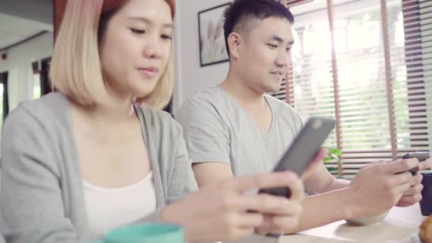 Atractiva Pareja Asiática Joven Distraída Mesa Con Periódico Teléfono Celular — Vídeo de stock