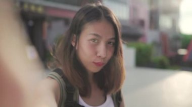 Beijing, Çin mahallesinde, seyahat ederken selfie alarak smartphone kullanan neşeli güzel genç Asyalı backpacker blogger kadın. Yaşam tarzı sırt çantası turizm seyahat tatil kavramı. Bakış açısı.