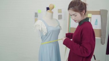 Profesyonel güzel Asyalı kadın moda ölçüm elbise bir manken giyim tasarım stüdyosunda üzerinde çalışan tasarımcı. Yaşam tarzı kadın kavramı çalışma.