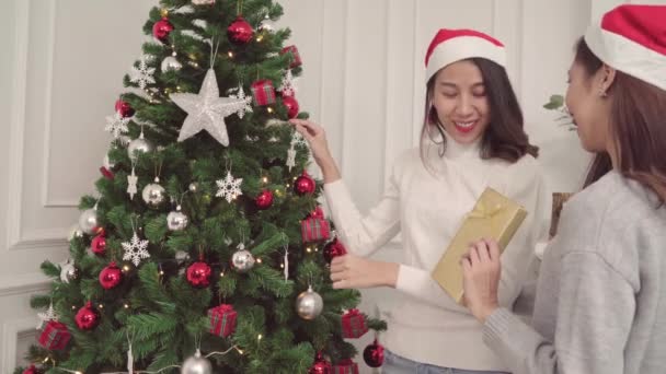 クリスマス フェスティバルで彼女のリビング ルームを自宅でお互いにクリスマス プレゼントを与えること陽気な幸せな若いアジア女性のグループ ライフ スタイルの女性を祝うクリスマスと新年のコンセプト — ストック動画