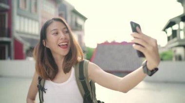 Beijing, Çin mahallesinde, seyahat ederken selfie alarak smartphone kullanan neşeli güzel genç Asyalı backpacker blogger kadın. Yaşam tarzı sırt çantası turizm seyahat tatil kavramı.