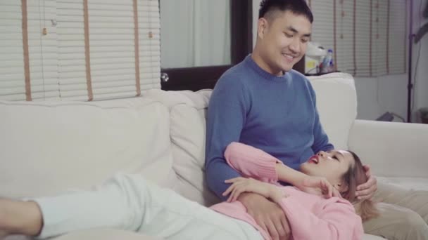 在家里的客厅里放松的时候 幸福甜蜜的亚洲夫妇的肖像有浪漫的时间躺在沙发上 在舒适的家中使用放松时间的生活方式夫妇 — 图库视频影像