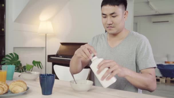 快乐的亚洲男人在早上醒来后吃早餐 牛奶麦片 面包和喝橙汁 生活方式的人在家里吃东西的概念 — 图库视频影像