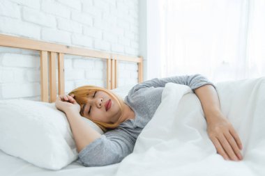 Sabahleyin yatakta uyuyan güzel genç Asyalı kadın. Çekici Asyalı kız rahat yatak odasında uyku zamanı kullanın. Gevşeme yatak odası. Hayat tarzı Asya kadın ev concept.