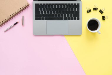Yaratıcı düz fotoğraf çalışma masası yatıyordu. Üstten Görünüm ofis büro dizüstü bilgisayar, boş boş defter ve kahve fincanı pastel renk arka plan üzerinde. Kopya alanı, düz yatıyordu fotoğraf ile Üstten Görünüm.