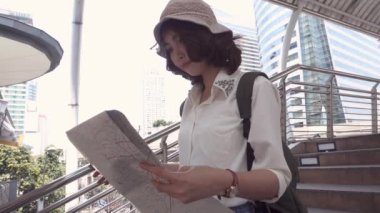 Yavaş hareket - neşeli güzel genç Asyalı backpacker kadın yön ve Bangkok, Tayland, Thailand seyahat ederken konumu harita üzerinde seyir. Yaşam tarzı sırt çantası turizm seyahat tatil kavramı.