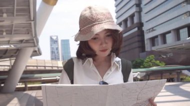 Yavaş hareket - neşeli güzel genç Asyalı backpacker kadın yön ve Bangkok, Tayland, Thailand seyahat ederken konumu harita üzerinde seyir. Yaşam tarzı sırt çantası turizm seyahat tatil kavramı.