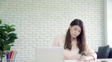 Asya iş kadını ofiste çalışan dizüstü bilgisayar ile onun meslektaşım kahve verilmesi. Grup ofis fikirleri tartışmak raslantı giyimli iş adamları.