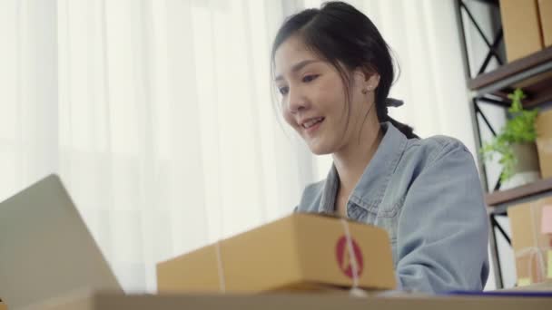 美しいスマートなアジア若い起業家女性経営者中小企業のオンラインは在庫製品をチェックし 自宅のコンピューターで仕事を保存します ホーム オフィスのコンセプトでスモール ビジネス オーナー — ストック動画