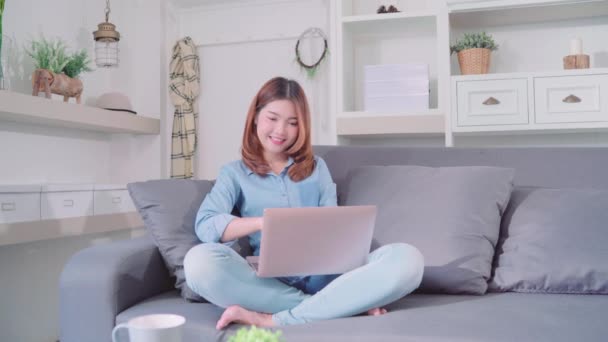 매력적인 아시아 여자는 소파에 컴퓨터 노트북을 집에서 거실에서 개념을 집에서 — 비디오