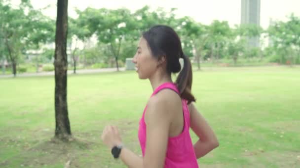 スロー モーションで健康的な美しい若いアジア ランナー女性スポーツ衣料品を実行している 都市公園の通りにジョギングします ライフ スタイルに合わせて 都市のコンセプトで活動的な女性運動 — ストック動画