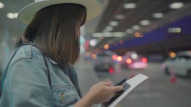Kullanarak ve uçağının kalkış kapısı uluslararası havaalanında beklerken onun smartphone terminal salonunda kontrol mutlu Asyalı kadın. Kadınlar Havaalanı kavramında mutlu.