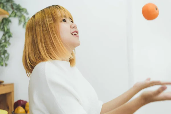 Asiatisk Vakker Kvinne Spiser Oransje Kjøkkenet Hjemme Hos Seg Lykkelig – stockfoto