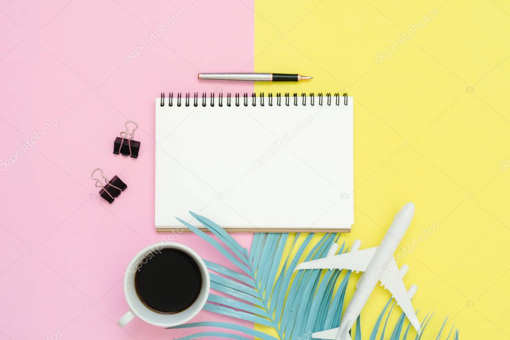 Flat lay design of travel summer concept - Top view mockup of blank paper notebook, pen, pastel leaf, coffee and plane on pink yellow pastel color screen. Travel in summer on pastel color background.