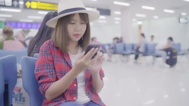 Kullanarak Onun Smartphone Uçağının Kalkış Kapısı Uluslararası Havaalanında Beklerken Terminal — Stok video