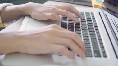 Asyalı kadın çalışma dizüstü evde oturma odasında masa üzerinde gülümseyen güzel genç. Asya iş kadını defter belge finans ve hesap makinesi ev ofis yazma. Ev concept anda zevk.
