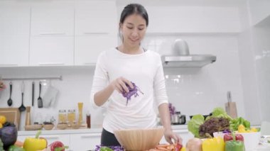 Genç Asyalı kadın evde fit vücut salata hazırlama beslenme organik sebze çok mutfakta, gündelik kullanımda güzel erkek salata sağlıklı gıda yapma. Sağlıklı gıda kavramı.