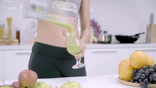 运动中的亚洲女人在厨房里喝苹果汁 美丽的女性穿着运动服 在家里用有机水果丰富的营养制作苹果汁 健康食品理念 — 图库视频影像