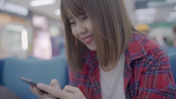 Mujer Asiática Feliz Usando Comprobando Teléfono Inteligente Mientras Está Sentada — Vídeo de stock