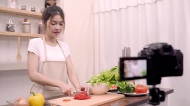 Blogger Asyalı kadın nasıl salata sağlıklı gıda için onun abone, kadın kullanımı organik sebze salata evde fit vücut için hazırlama video yapmak için kayıt kamerayı kullanarak. Sağlıklı gıda kavramı.