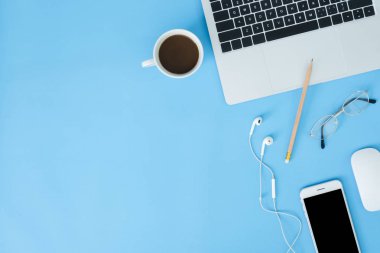 Ofis Masası adlı kullanıcının alanı - düz çalışma üstten görünüm mockup fotoğraf çalışma alanı dizüstü bilgisayar, akıllı aygıt ve bir fincan kahve pastel mavi zemin üzerine yatırın. Pastel mavi renk kopyalama alanı çalışma alanı kavramı.