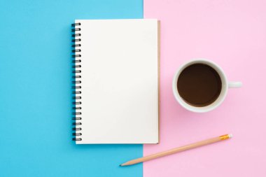 Yaratıcı düz Fotoğraf çalışma masası yatıyordu. Üstten görünüm ofis masası mavi pembe renkli arka plan üzerinde kalem, defter ve kahve Kupası ile. Kopya alanı, düz yatıyordu fotoğraf ile üstten görünüm.