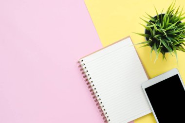 Ofis Masası adlı kullanıcının alanı - düz çalışma üstten görünüm fotoğraf çalışma alanı boş sahte tablet, ağaç bitki ve defter pastel zemin üzerine yatırın. Pastel pembe sarı renkli kopya alanı çalışma Resepsiyon kavramı.