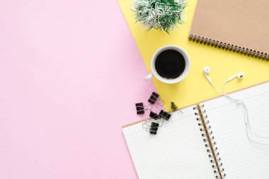 Yaratıcı düz fotoğraf çalışma masası yatıyordu. Üstten Görünüm ofis büro dizüstü bilgisayarlar, bitki, pastel renkli arka plan üzerinde kahve Kupası, kulaklık ve kopya alanı ile. Kopya alanı, düz yatıyordu fotoğraf ile Üstten Görünüm.