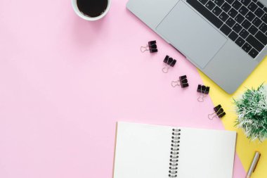 Yaratıcı düz fotoğraf çalışma masası yatıyordu. Üstten Görünüm ofis büro dizüstü bilgisayar, boş boş defter ve kahve fincanı pastel renk arka plan üzerinde. Kopya alanı, düz yatıyordu fotoğraf ile Üstten Görünüm.