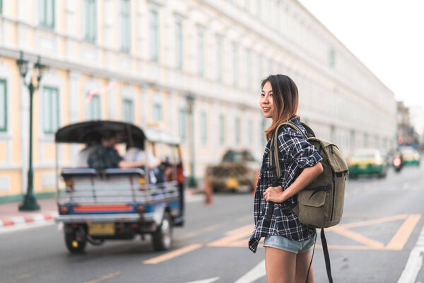 Traveler backpacker asian woman travel in Bangkok, Thailand. Happy young female spending holiday trip at amazing landmark and enjoy her journey in traditional city.