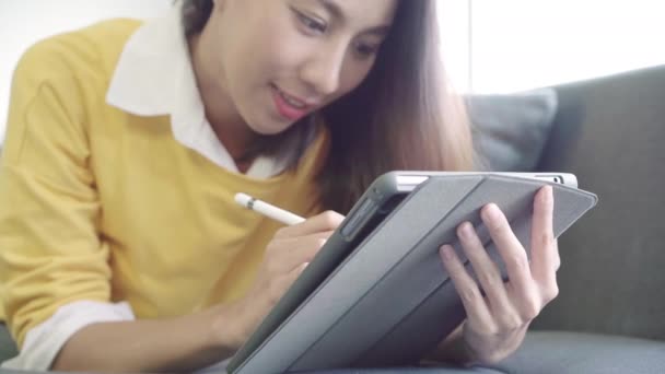 아시아 스웨터 집에서 거실에서 소파에 비디오를 태블릿을 라이프 스타일 개념에 — 비디오