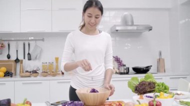 Genç Asyalı kadın evde fit vücut salata hazırlama beslenme organik sebze çok mutfakta, gündelik kullanımda güzel erkek salata sağlıklı gıda yapma. Sağlıklı gıda kavramı.