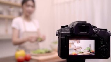 Blogger Asyalı kadın nasıl salata sağlıklı gıda için onun abone, kadın kullanımı organik sebze salata evde fit vücut için hazırlama video yapmak için kayıt kamerayı kullanarak. Sağlıklı gıda kavramı.