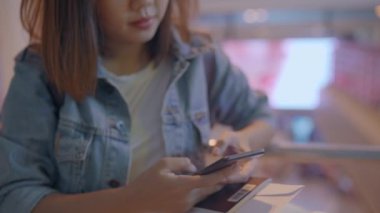 Kullanarak ve uçağının kalkış kapısı uluslararası havaalanında beklerken onun smartphone terminal salonunda kontrol mutlu Asyalı kadın. Kadınlar Havaalanı kavramında mutlu.