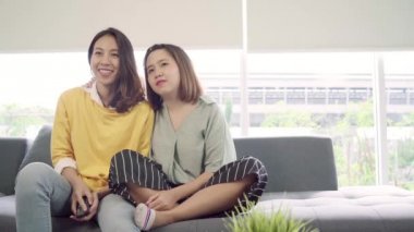 Lezbiyen çift evde oturma odasında gülmek Tv izlerken, tatlı çift kanepede yatarken komik an zevk Asya ne zaman evde dinlenin. Yaşam tarzı çift evde kavramı relax.