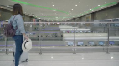 Kullanarak ve uçağının kalkış kapısı uluslararası havaalanında beklerken onun smartphone terminal salonunda kontrol mutlu Asyalı kadın. Kadınlar Havaalanı kavramında mutlu.