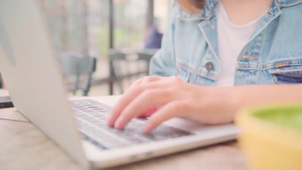 商务自由的亚洲女性在咖啡馆坐在桌旁工作 做项目 在笔记本电脑上发送电子邮件 生活方式聪明的美女在咖啡店工作的概念 — 图库视频影像