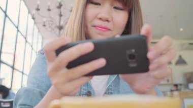 Kadın blogger yeşil çay bardağı Cafe telefonu ile fotoğraf çekmek. Bir genç kadın alarak fotoğraf kahve çay Smartphone, yemek Mobil kamera ile fotoğraf çekimi.