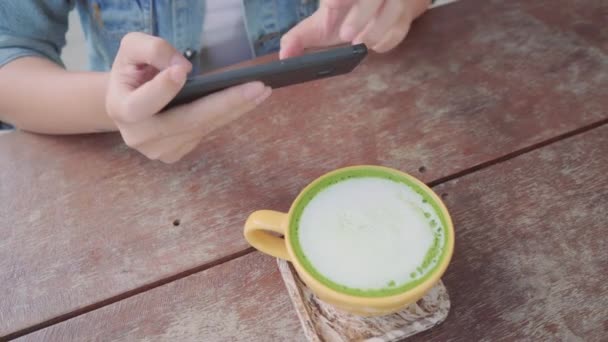 Жінка Блогер Фотографує Чашку Зеленого Чаю Кафе Своїм Телефоном Молода — стокове відео
