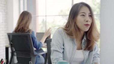 Asya yaratıcı iş kadınları müzik dinleme ve birlikte dans, Erkek dinlenmek büroda çalıştıktan sonra. Yaşam tarzı kadın iş yerinde office kavramı