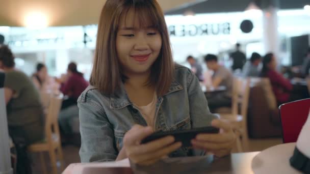 Szczęśliwy Asian Kobieta Przy Użyciu Sprawdzanie Jej Smartphone Siedząc Krześle — Wideo stockowe